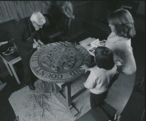 奥蒂斯·斯蒂芬斯向两位客人展示木雕，1980年