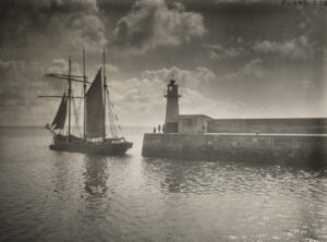 一艘停泊在小灯塔附近的纵帆船。